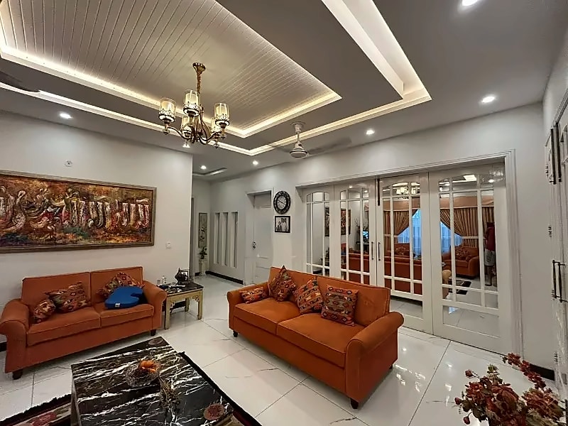 Lounge with tiled floor, ceiling details and glazed doors in the D-12/4 house; furniture is not included in the rental